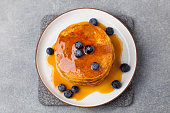 Pumpkin pancakes with maple syrup and blueberries. Top view