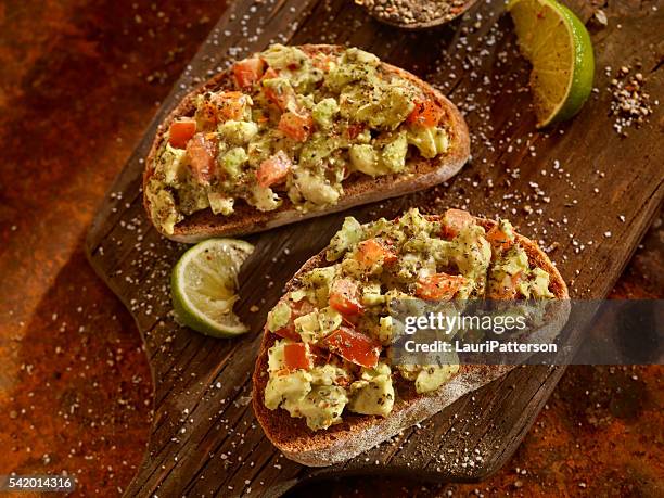 avocado toast with tomatoes on rye bread - avocado toast stock pictures, royalty-free photos & images