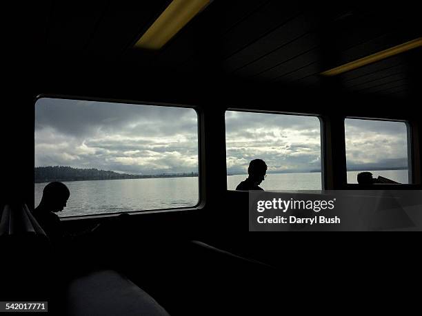 Clouds line the horizon as seen through windows of a Washington State ferry carrying passengers on the way across Puget Sound from Bainbridge Island...