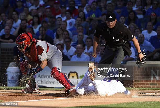 Chris Coghlan of the Chicago Cubs is safe at home as Yadier Molina of the St. Louis Cardinals takes a late throw during the first inning on June 21,...