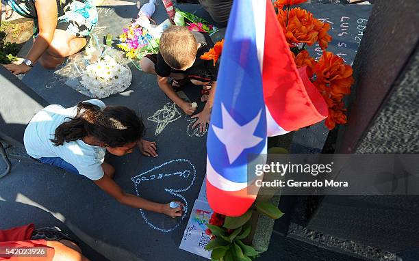 Kids write messages for the victims of the Pulse Nightclub shooting at the front of the nightclub on June 21, 2016 in Orlando, Florida. The Orlando...