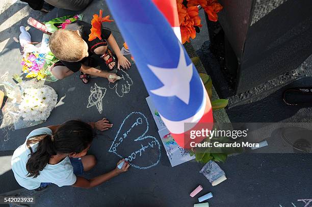 Kids write messages for the victims of the Pulse Nightclub shooting at the front of the nightclub on June 21, 2016 in Orlando, Florida. The Orlando...