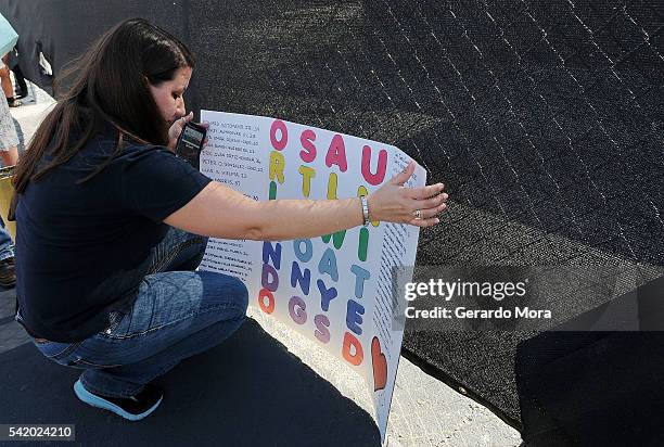 Woman leave a sign for the victims of the Pulse Nightclub shooting at the front of the nightclub building on June 21, 2016 in Orlando, Florida. The...