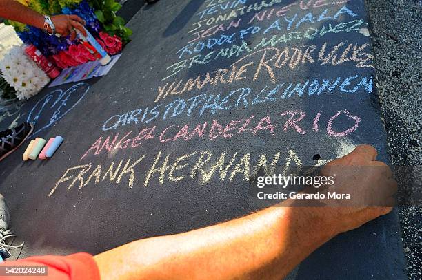 Edwin Rodriguez writes the names of the victims of the Pulse Nightclub shooting at the front of the nightclub building on June 21, 2016 in Orlando,...