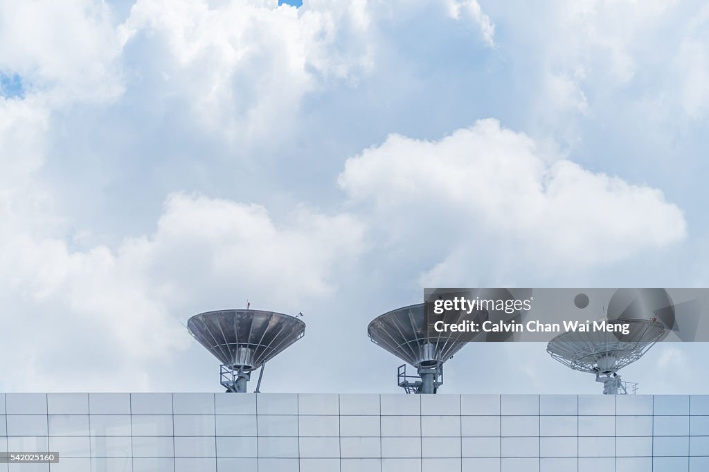 Three radio satellites and cloudy background