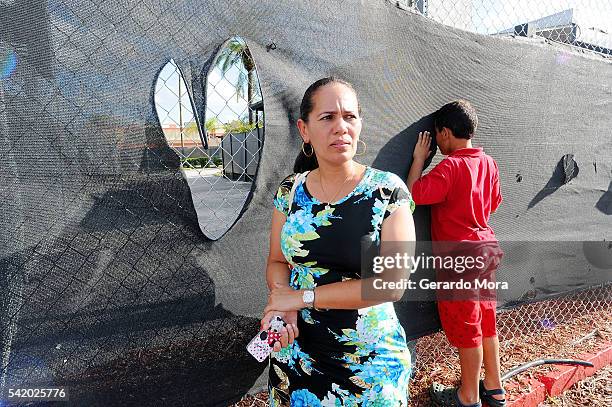 Zila Zurita and her son Juan Tatis Zurita pay their respects for the victims of the Pulse Nightclub shooting at the front of the nightclub building...