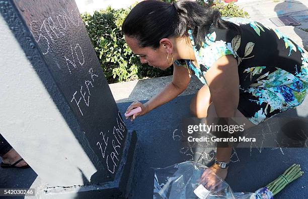 Zila Zurita pays her respects to the victims of the Pulse Nightclub shooting at the front of the nightclub building on June 21, 2016 in Orlando,...