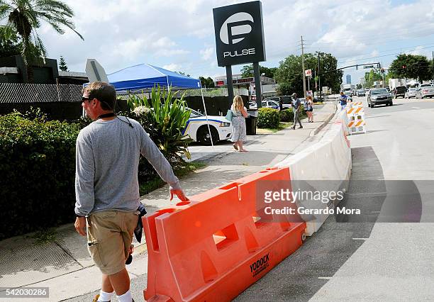 People pay their respects to the victims of the Pulse Nightclub shooting at the front of the nightclub building on June 21, 2016 in Orlando, Florida....