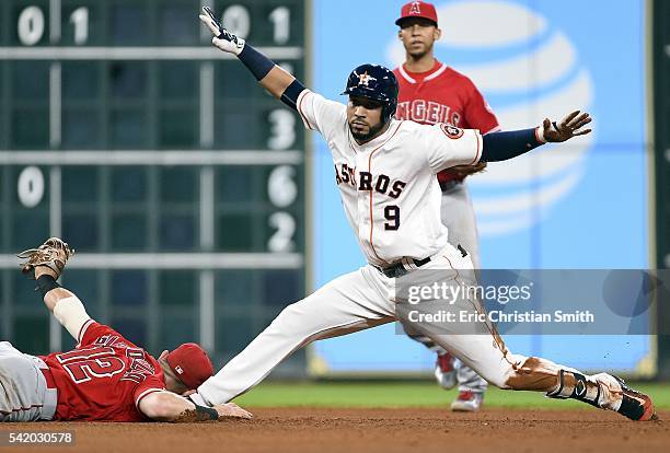 Marwin Gonzalez of the Houston Astros signals himself safe after hitting a double, beating the tag of Johnny Giavotella of the Los Angeles Angels of...