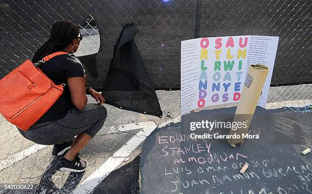 Woman looks through a fence at the site of the Pulse nightclub building on June 21, 2016 in Orlando, Florida. The Orlando community continues to...