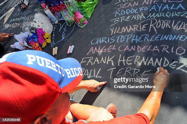 Edwin Rodriguez writes the names of the victims of the Pulse nightclub shooting in front of the club on June 21, 2016 in Orlando, Florida. The...
