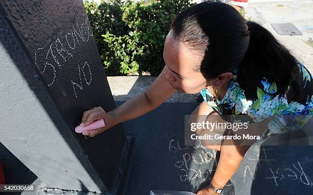 Zila Zurita pays her respects to the victims of the Pulse nightclub shooting at the front of the nightclub building on June 21, 2016 in Orlando,...