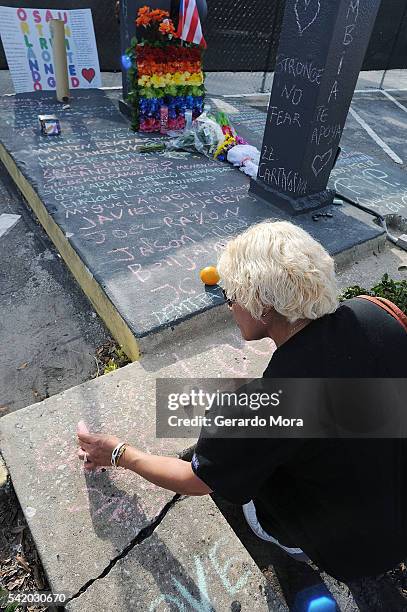 Woman pays her respects to the victims of the Pulse nightclub shooting at the front of the nightclub building on June 21, 2016 in Orlando, Florida....