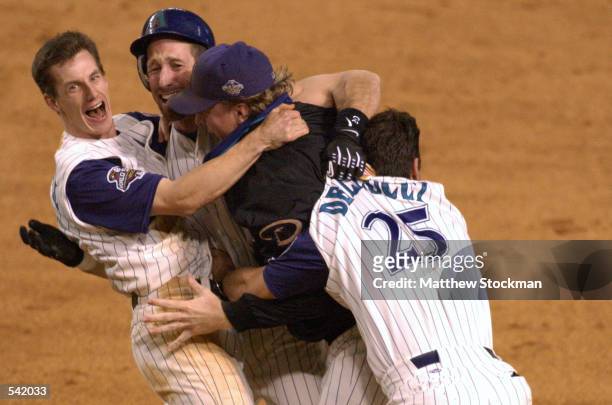 Craig Counsell, Luis Gonzalez, Curt Schilling and David Dellucci of the Arizona Diamondbacks celebrate defeating the New York Yankees to win game...