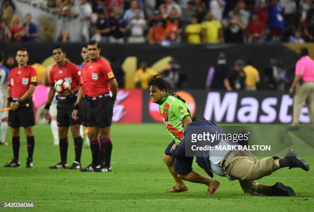 Football fan is tackled by security personnel after stepping onto the field at the end of the Copa America Centenario semifinal football match...
