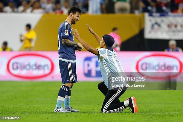 Lionel Messi of Argentina interacts with a fan who ran onto the field prior to the start of the second half during a 2016 Copa America Centenario...