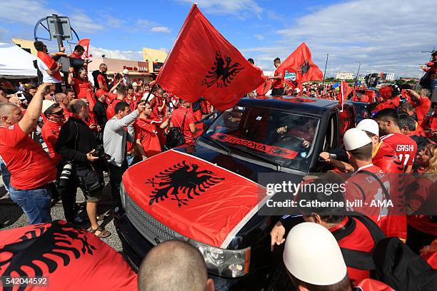 Car with an Albanian flag on the bonnet drives gets stuck in amongst a group fans who are enjoying themselves before the UEFA EURO 2016 Group A match...