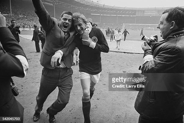 Scottish football player Denis Law is hugged by a fan after Scotland beat England 3-2 at an international match at Wembley Stadium, London, 15th...