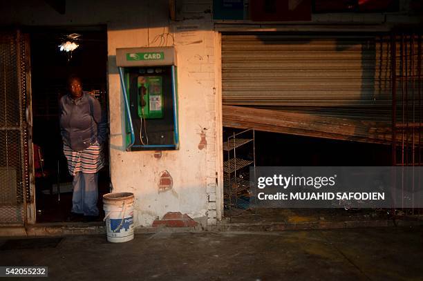 Jostina Mohlamonyne stands outside her shop after it was looted by residents of Mamelodi, north-east of Pretoria, after violence erupted over the...