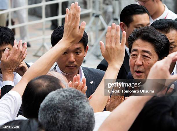 Japanese Prime Minister and Liberal Democratic Party President Shinzo Abe gives high fives to supporters as he arrives for an election campaign rally...