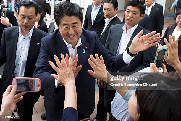 Japanese Prime Minister and Liberal Democratic Party President Shinzo Abe gives high fives to supporters as he arrives for an election campaign rally...