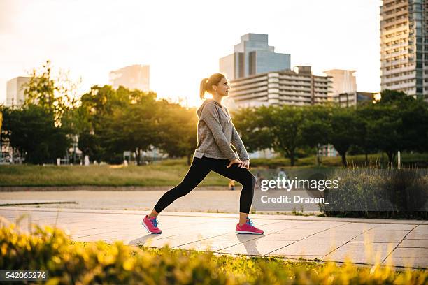 ストレッチスポーツの女性日没での街、大阪（日本） - 柔軟 ストックフォトと画像