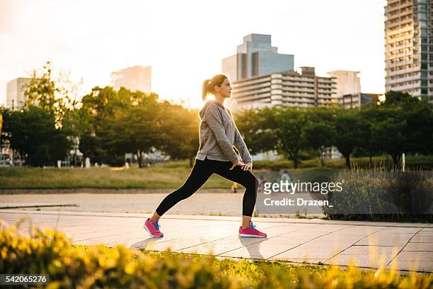 sports woman stretching in sunset in city of osaka, japan - warming up 個照片及圖片檔