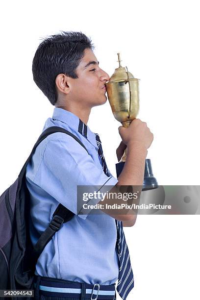 successful young boy kissing trophy against white background - life after stroke awards 2011 ストックフォトと画像