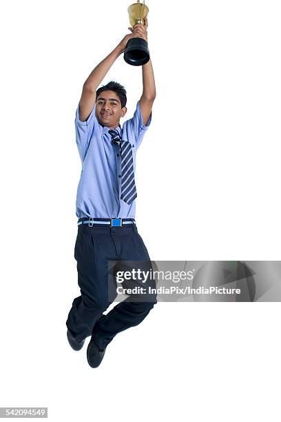 full length of a boy jumping in air with trophy against white background - life after stroke awards 2011 stock pictures, royalty-free photos & images