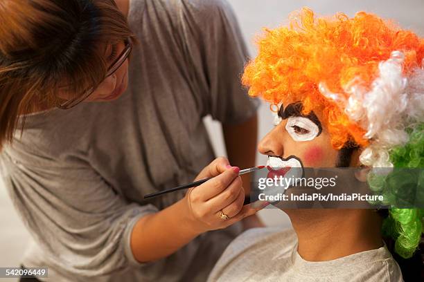 make up artist applying make up to clown - peinture corporelle photos et images de collection