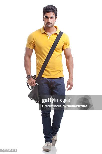 portrait of young man walking over white background - carrying sports bag foto e immagini stock