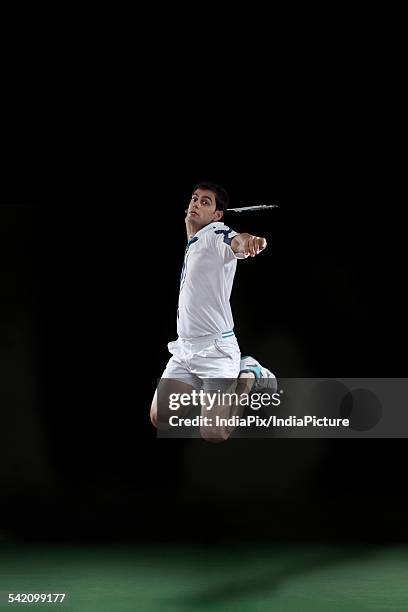 badminton player leaps high in the air and prepares to smash a shuttlecock - badminton smash stock pictures, royalty-free photos & images