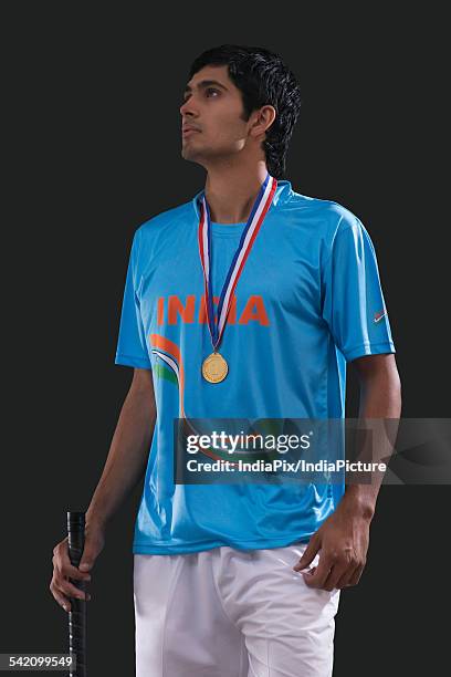 young hockey player looking up with pride against black background - hockey player black background stock pictures, royalty-free photos & images