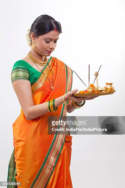 maharashtrian woman praying while holding a puja thali - hinduism stock pictures, royalty-free photos & images