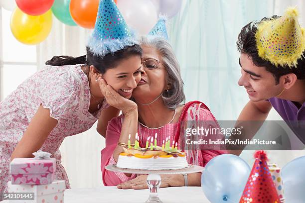 woman celebrating birthday with grandchildren - light vivid children senior young focus stock pictures, royalty-free photos & images