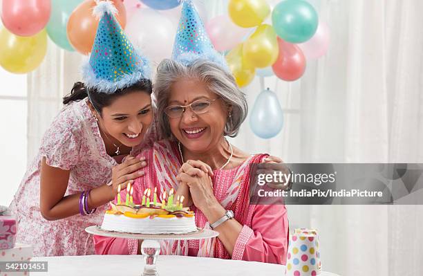 woman celebrating birthday with granddaughter - light vivid children senior young focus stock pictures, royalty-free photos & images