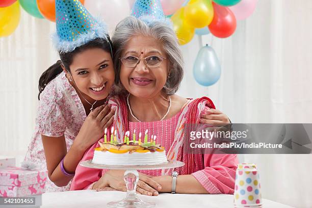woman celebrating birthday with granddaughter - light vivid children senior young focus foto e immagini stock