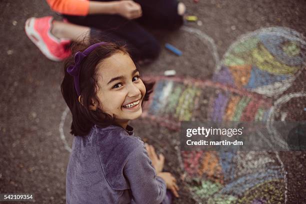 bambini disegno con gesso sull'asfalto - gessetto da lavagna foto e immagini stock