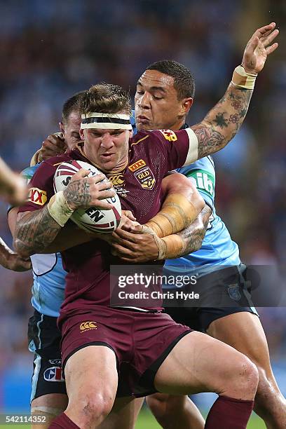 Josh McGuire of the Maroons is tackled by Paul Gallen and Tyson Frizell of the Blues during game two of the State Of Origin series between the...