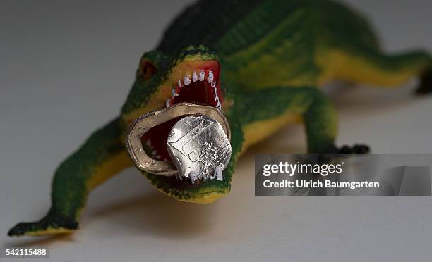 Squashed 1 Euro coin in the muzzle of a crocodile. Symbol photo on the subjects Brexit , European Union , European Central Bank , European Economc...