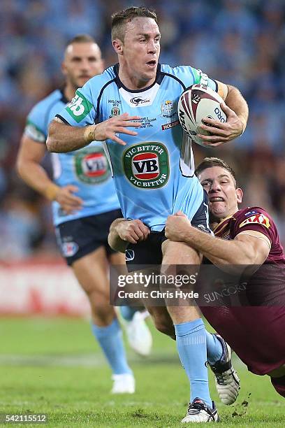 James Maloney of the Blues is tackled by Jacob Lillyman of the Maroons during game two of the State Of Origin series between the Queensland Maroons...