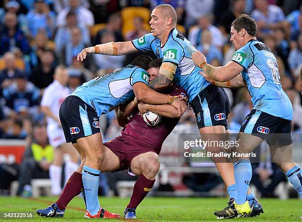 Jacob Lillyman of the Maroons is wrapped up by the defence during game two of the State Of Origin series between the Queensland Maroons and the New...