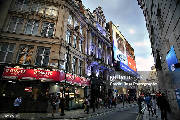 illuminated buildings along glasshouse street, a side streets of piccadilly circus in london, england - crowded underground london stock pictures, royalty-free photos & images