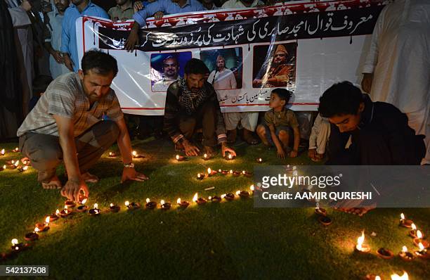 Pakistani Shiite Muslim protesters light oil lamps to pay tribute to Sufi musician Amjad Sabri who was killed in an attack by unknown gunmen, in...