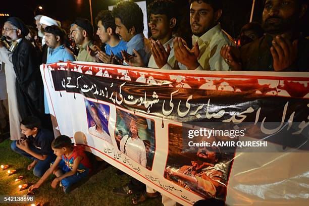 Pakistani Shiite Muslim protesters pray as they pay tribute to Sufi musician Amjad Sabri who was killed in an attack by unknown gunmen, in Islamabad...