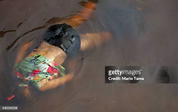 The dead body of a female victim of Hurricane Katrina floats in the water surrounding the Superdome September 2, 2005 in New Orleans, Louisiana....