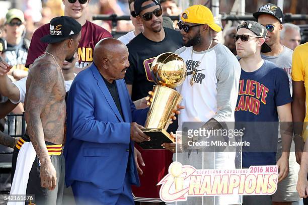 Hall of Famer and former Cleveland Brown Jim Brown hands the Larry O'Brien Trophy to LeBron James of the Cleveland Cavaliers during the Cleveland...