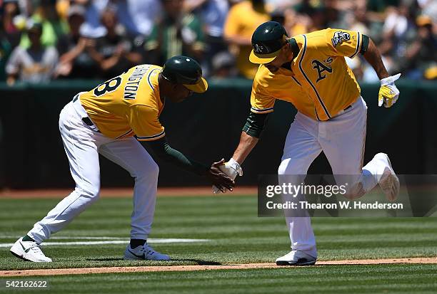 Coco Crisp of the Oakland Athletics is congratulated by third base coach Ron Washington after he hit a solo home run against the Milwaukee Brewers in...