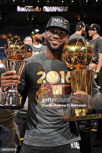 LeBron James of the Cleveland Cavaliers celebrates with the Bill Russell NBA Finals Most Valuable Player Award and the Larry O'Brien NBA Championship...