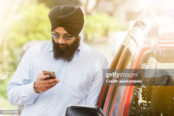 sikh mann, mit smartphone, - punjab stock-fotos und bilder